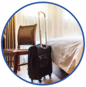 a chair and a rolling suitcase inside a hotel room